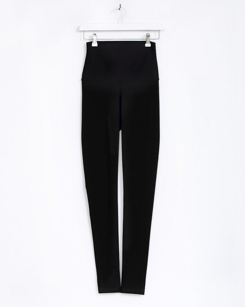 Black leggings on a white hanger against a white background