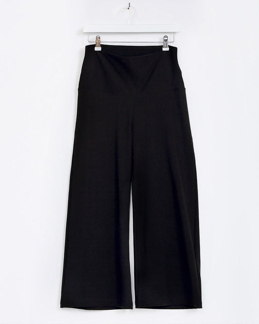 Black wide-leg pants hanging on a white background